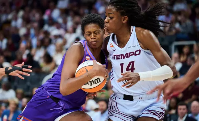 Phoenix Mercury's Valeriane Ayayi (11) crashes into Toronto Tempo's Temi Fagbenle (14) during first half of an WNBA basketball game in Toronto, on Saturday, June 27, 2026. (Sammy Kogan /The Canadian Press via AP)