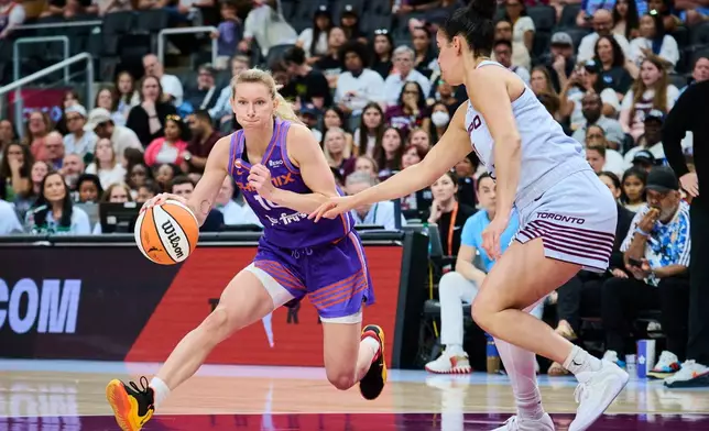Phoenix Mercury's Lexi Held (10) drives past Toronto Tempo's Kia Nurse (11) during first half of an WNBA basketball game in Toronto, on Saturday, June 27, 2026. (Sammy Kogan /The Canadian Press via AP)
