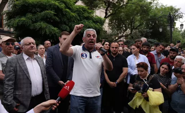 A man gestures speaking to demonstrators of opposition parties, in protest of the results of the parliamentary elections in Yerevan, Armenia, Sunday, June 14, 2026. (AP Photo/Anthony Pizzoferrato)