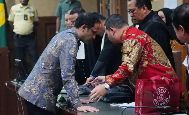 The co-founder of ride-hailing and payment giant Gojek and fomer Indonesian Education Minister Nadiem Anwar Makarim, left, speaks with his lawyers after being sentenced in a Google Chromebook laptop procurement corruption case, at the Corruption Court in Jakarta, Indonesia, Tuesday, June 30, 2026. (AP Photo/Tatan Syuflana)