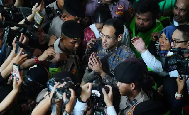 Fomer Education Minister Nadiem Anwar Makarim, center, who is also the co-founder of ride-hailing and payment giant Gojek, talks to the media after his sentencing hearing in a Google Chromebook laptop procurement corruption case, at the Corruption Court in Jakarta, Indonesia, Tuesday, June 30, 2026. (AP Photo/Tatan Syuflana)