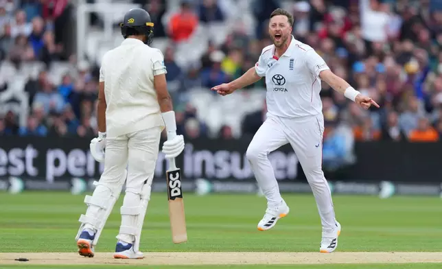 England's Ollie Robinson, right, celebrates the dismissal of New Zealand's Rachin Ravindra, left, during the third day of the Test match between England and New Zealand at Lord's cricket ground in London, Saturday, June 6, 2026. (AP Photo/Kirsty Wigglesworth)