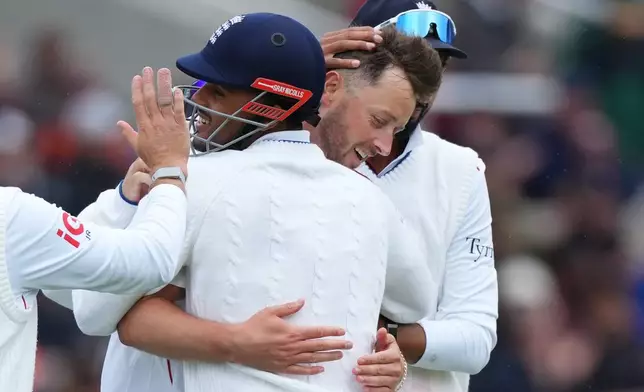 England's Ollie Robinson, center, celebrates with teammates after the dismissal of New Zealand's Rachin Ravindra during the third day of the Test match between England and New Zealand at Lord's cricket ground in London, Saturday, June 6, 2026. (AP Photo/Kirsty Wigglesworth)