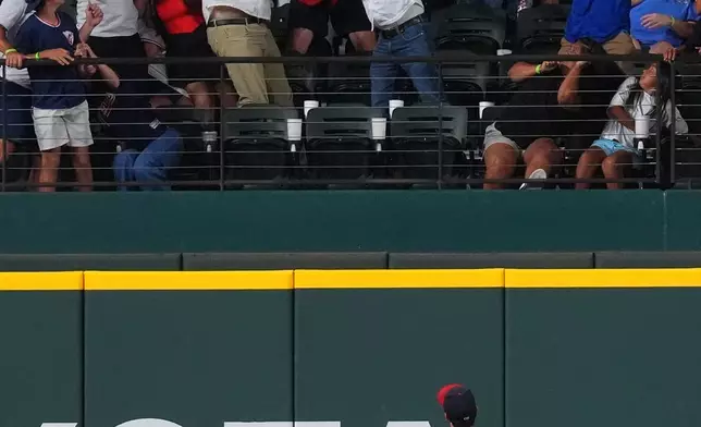 Cleveland Guardians outfielder Steven Kwan (38) looks on as fans in the stands reach for Texas Rangers' Corey Seager's home run during the sixth inning of a baseball game, Friday, June 5, 2026, in Arlington, Texas. (AP Photo/LM Otero)