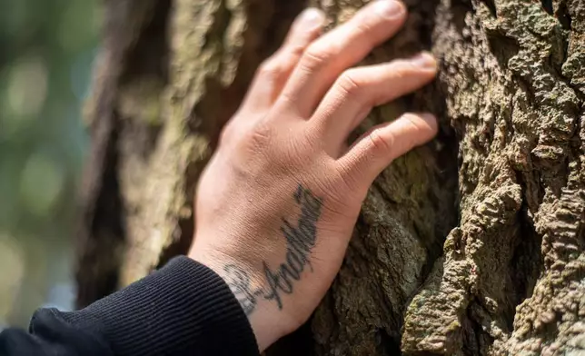 Gabriel Martinez Garcia rests his hand on a tree as his mother's name tattoo is visible on his wrist, in Tenino, Wash., on Sunday, June 14, 2026. (AP Photo/Akash Pamarthy)