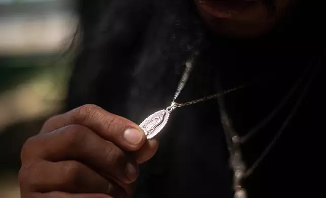 Gabriel Martinez Garcia, 30, holds a Hail Mary necklace given to him by his mother, which he wears every day, in Tenino, Wash., on Sunday, June 14, 2026. (AP Photo/Akash Pamarthy)
