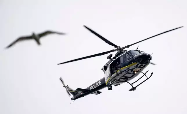 A Montreal police helicopter surveils the area near the scene of a shooting in Montreal on Monday, June 22, 2026. (Christopher Katsarov/The Canadian Press via AP)