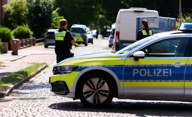 Police officers patrol the scene in Stad, Germany, Monday, June 29, 2026 following a shooting where five people were killed, police said. (Marcus Golejewski/dpa via AP)