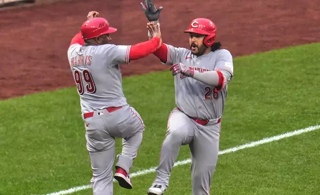 Cincinnati Reds' Eugenio Suárez, right, celebrates with third base coach Willie Harris (99) as he rounds the bases after hitting a three-run home run off Pittsburgh Pirates pitcher Gregory Soto during the ninth inning of a baseball game in Pittsburgh, Saturday, June 27, 2026. (AP Photo/Gene J. Puskar)