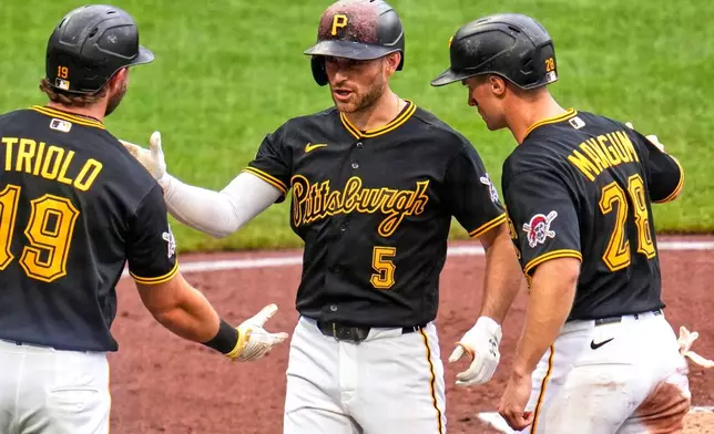 Pittsburgh Pirates' Brandon Lowe (5) celebrates with Jared Triolo (19) and Jake Mangum (28) after they all scored on his three-run home run off Cincinnati Reds pitcher Chase Burns during the third inning of a baseball game in Pittsburgh, Saturday, June 27, 2026. (AP Photo/Gene J. Puskar)