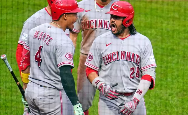 Cincinnati Reds' Eugenio Suárez (28) celebrates with Noelvi Marte (4) as he returns to the dugout after hitting a three-run home run off Pittsburgh Pirates pitcher Gregory Soto during the ninth inning of a baseball game in Pittsburgh, Saturday, June 27, 2026. (AP Photo/Gene J. Puskar)
