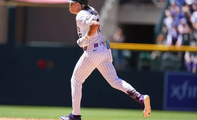 Colorado Rockies' Cole Carrigg circles the bases after hitting a solo home run off Chicago Cubs starting pitcher Edward Cabrera in the fourth inning of a baseball game Thursday, June 11, 2026, in Denver. (AP Photo/David Zalubowski)