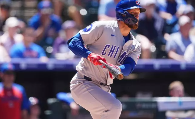 Chicago Cubs' Michael Busch follows his RBI single off Colorado Rockies relief pitcher Blas Castaño in the fifth inning of a baseball game Thursday, June 11, 2026, in Denver. (AP Photo/David Zalubowski)