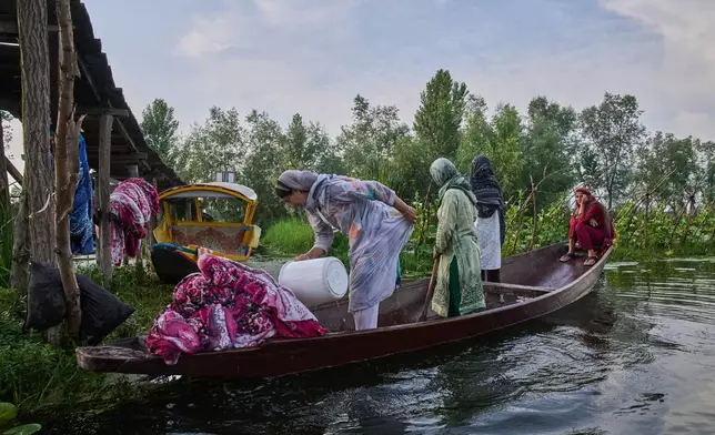 Kashmiri women on a boat wash blankets in the interiors of Dal Lake in Srinagar, Monday, June 1, 2026. (AP Photo/Dar Yasin)