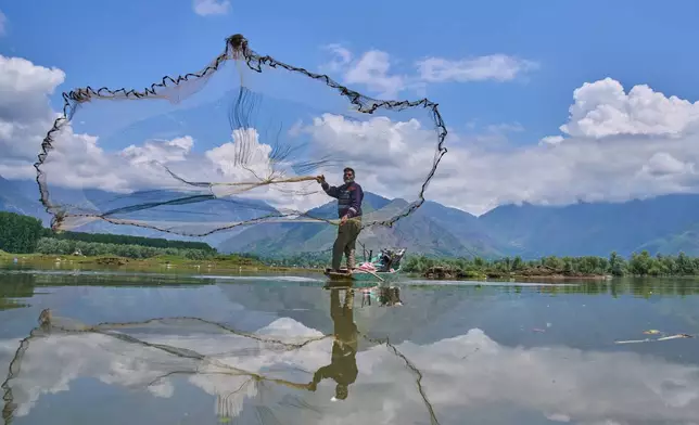Abdul Rasheed, a fisher, casts his net into the waters of Wular Lake in Bandipora, northeast of Srinagar, Indian controlled Kashmir, Tuesday, May 5, 2026. (AP Photo/Dar Yasin)