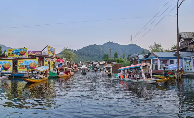 Tourists enjoy a ride on a traditional boat near the floating market on Dal Lake in Srinagar, Indian controlled Kashmir, Monday, June 1, 2026. (AP Photo/Dar Yasin)
