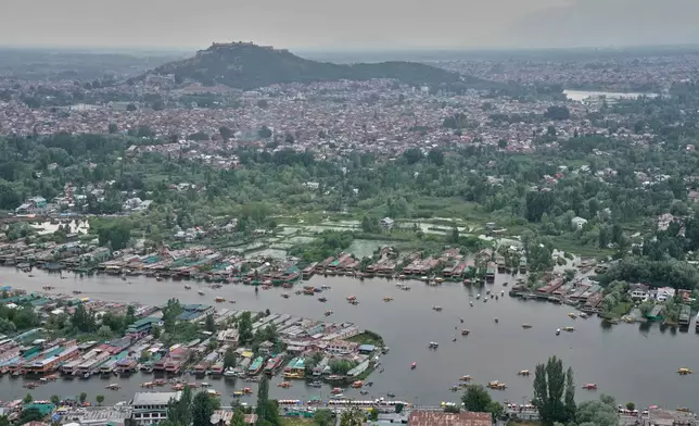 Boats maneuver the waters of Dal Lake in Srinagar, Indian controlled Kashmir, Thursday, June 4, 2026. (AP Photo/Dar Yasin)