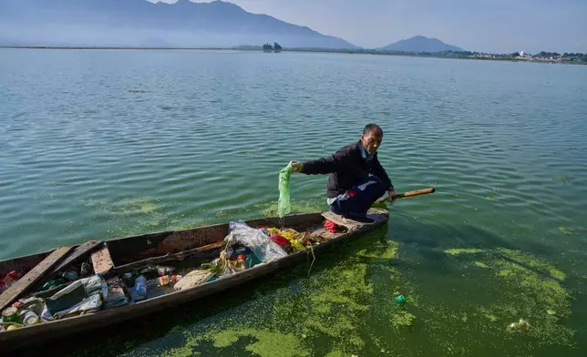Mohammad Amin, a Kashmiri laborer employed by a nonprofit organization that collects garbage floating on Dal Lake, works on the outskirts of Srinagar, Indian controlled Kashmir, Monday, May 4, 2026. (AP Photo/Dar Yasin)