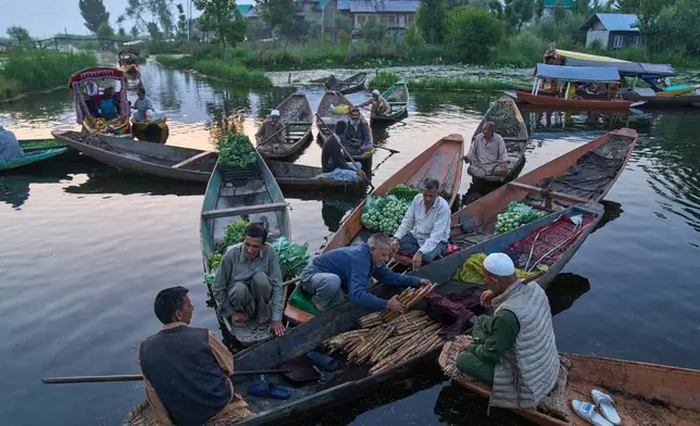 Kashmiri men sell their produce early in the morning at the floating vegetable market on Dal Lake in Srinagar, Indian Controlled Kashmir, Monday, May 18, 2026. (AP Photo/Dar Yasin)