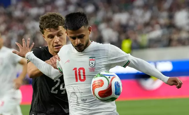 Iran's Mehdi Ghayedi (10) battles for the ball with New Zealand's Callan Elliot (24) during the World Cup Group G soccer match between Iran and New Zealand in Inglewood, Calif., near Los Angeles, Monday, June 15, 2026. (AP Photo/Andre Penner)