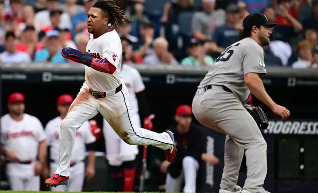 Cleveland Guardians' Jose Ramirez, left, runs home to score a run on an RBI single by Chase DeLauter during the third inning of a baseball game against the New York Yankees, Tuesday, June 9, 2026, in Cleveland. (AP Photo/David Dermer)