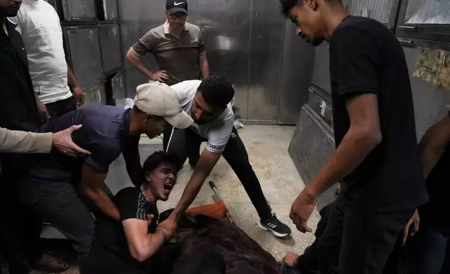 Palestinians mourn over the body of Mohammed Al-Harazin at the morgue of Shifa Hospital after he was killed in an Israeli airstrike on a vehicle in Gaza City, Sunday, June 7, 2026. (AP Photo/Jehad Alshrafi)