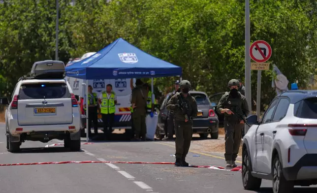 Israeli security forces and ZAKA rescue service volunteers respond at the scene of a shooting attack carried out by a Palestinian citizen of Israel near Tzur Yitzhak in central Israel, Sunday, June 7, 2026. (AP Photo/Ariel Schalit)