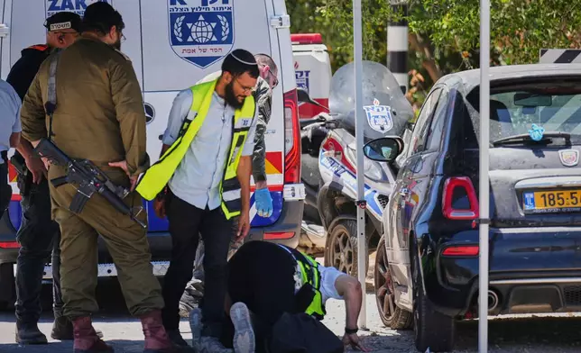 Israeli security forces and ZAKA rescue service volunteers respond at the scene of a shooting attack carried out by a Palestinian citizen of Israel near Tzur Yitzhak in central Israel, Sunday, June 7, 2026. (AP Photo/Ariel Schalit)
