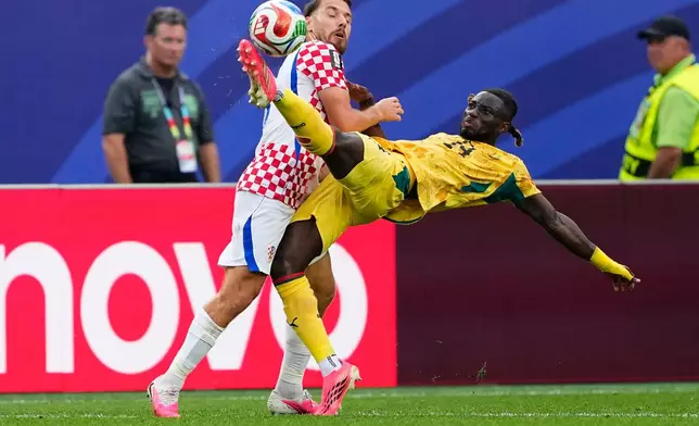 Croatia's Ivan Perisic (14), left, fights for the ball with Ghana's Gideon Mensah (14) during the World Cup Group L soccer match between Croatia and Ghana in Philadelphia, Saturday, June 27, 2026. (AP Photo/Petr Josek)