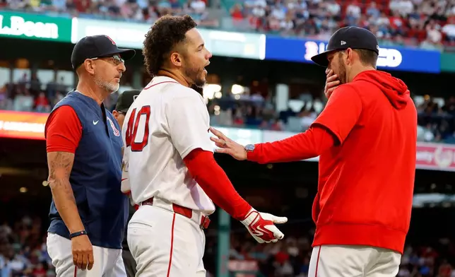 Boston Red Sox interim manager Chad Tracy, right, holds back Willson Contreras, center, after Contreras was thrown out for contesting a call during the second inning of a baseball game against the Washington Nationals, Monday, June 29, 2026, in Boston. (AP Photo/Mary Schwalm)