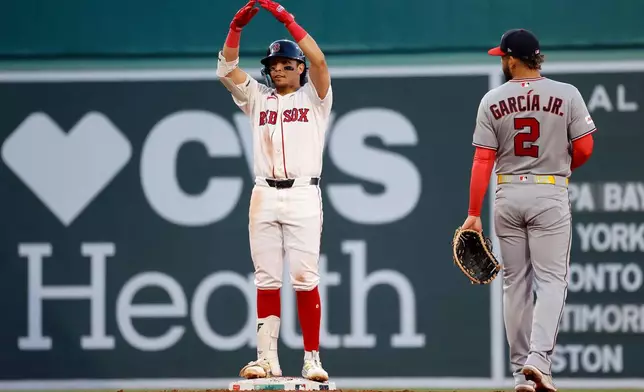 Boston Red Sox's Anthony Seigler, left, reacts to his dugout after hitting a double as Washington Nationals first baseman Luis García Jr. (2) looks on during the third inning of a baseball game, Monday, June 29, 2026, in Boston. (AP Photo/Mary Schwalm)