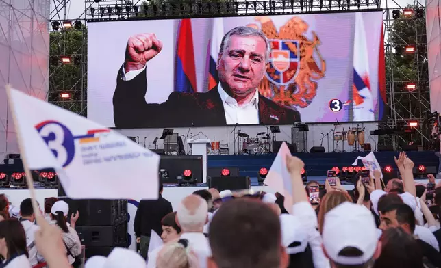 Supporters of Russian-Armenian tycoon Samvel Karapetyan, on screen, attend a rally against incumbent Prime Minister Nikol Pashinyan at Republic Square in Yerevan, Armenia, Wednesday, June 3, 2026. (AP Photo/Anthony Pizzoferrato)