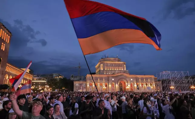 Supporters of Russian-Armenian tycoon Samvel Karapetyan, wave a Armenian national flag during a rally against incumbent Prime Minister Nikol Pashinyan at Republic Square in Yerevan, Armenia, Wednesday, June 3, 2026, as Karapetyan, who heads the Strong Armenia party, has faced criminal charges that he rejected as politically driven and campaigned from under house arrest. (AP Photo/Anthony Pizzoferrato)