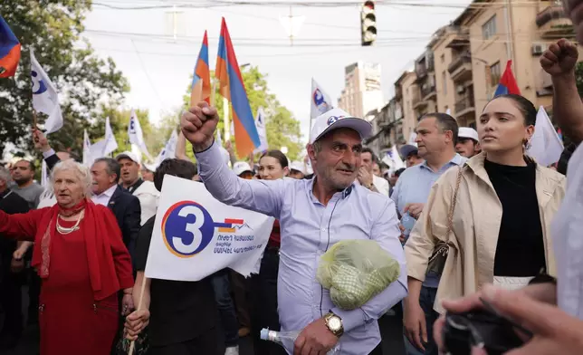 A man gestures as he and other supporters of Russian-Armenian tycoon Samvel Karapetyan, who heads Strong Armenia party, has faced criminal charges that he rejected as politically driven and campaigned from under house arrest, rally toward Republic Square against incumbent Prime Minister Nikol Pashinyan in Yerevan, Armenia, Wednesday, June 3, 2026. (AP Photo/Anthony Pizzoferrato)