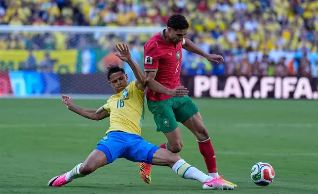 Brazil's Douglas Santos, left, challenges Morocco's Achraf Hakimi during the World Cup Group C soccer match between Brazil and Morocco in East Rutherford, N.J., near New York, Saturday, June 13, 2026. (AP Photo/Petr David Josek)