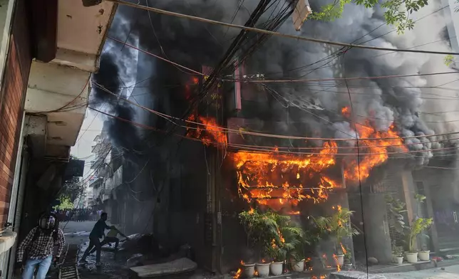 Local people attempt to douse a fire at a hotel in New Delhi, India, Wednesday, June 3, 2026. (AP Photo/Manish Swarup)