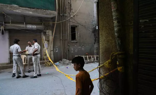 Policemen guard in front of a restaurant and hotel building that caught fire Wednesday, in New Delhi, India, Thursday, June 4, 2026. (AP Photo/Manish Swarup)