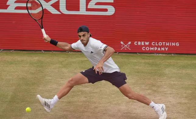 Francisco Cerundolo of Argentina, stretches to play a return to Tommy Paul of the United States during the men's final at the Queen's Club tennis championships in London, Sunday, June 21, 2026. (AP Photo/Maja Smiejkowska)