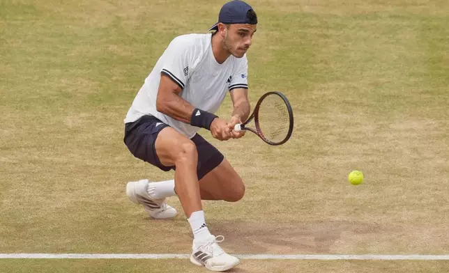Francisco Cerundolo of Argentina hits a return to Tommy Paul of the United States during the men's final at the Queen's Club tennis championships in London, Sunday, June 21, 2026. (AP Photo/Maja Smiejkowska)
