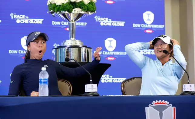 Yana Wilson, left, and Gina Kim react during a press conference after winning the Dow Championship LPGA golf tournament, Sunday, June 14, 2026, at Midland Country Club in Midland, Mich. (AP Photo/Al Goldis)