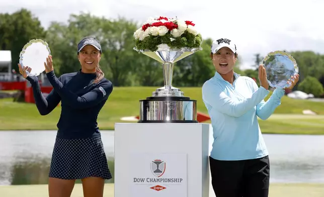 Yana Wilson, left, and Gina Kim, right, hold their trophies after winning the Dow Championship LPGA golf tournament, Sunday, June 14, 2026, at Midland Country Club in Midland, Mich. (AP Photo/Al Goldis)