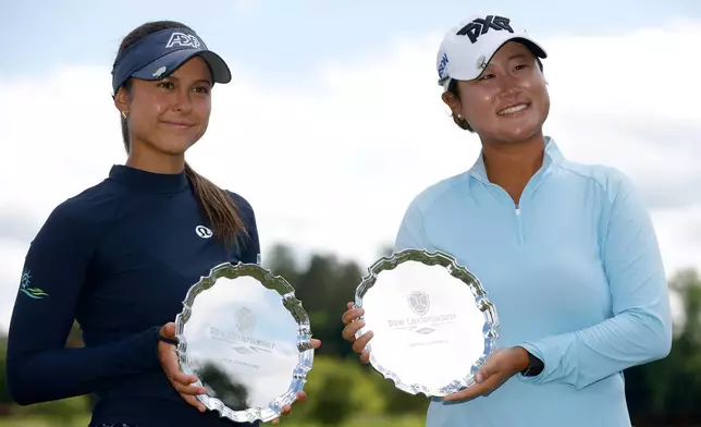 Yana Wilson, left, and Gina Kim hold their trophies after winning the Dow Championship LPGA golf tournament, Sunday, June 14, 2026, at Midland Country Club in Midland, Mich. (AP Photo/Al Goldis)