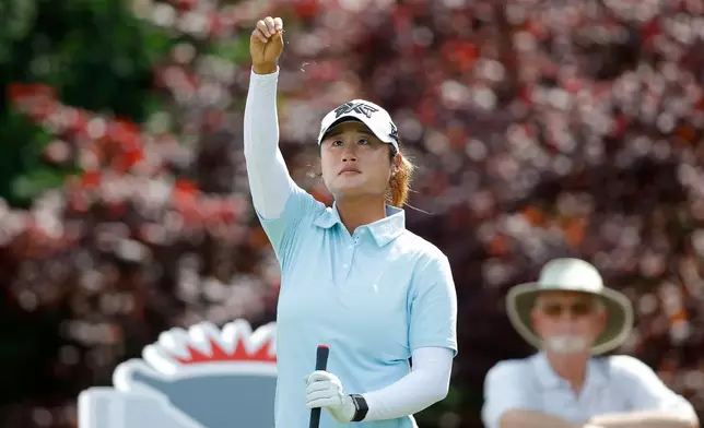 Gina Kim watches as she drops grass to check the wind before her tee shot on the 17th hole during the first round of the Dow Championship LPGA golf tournament, Thursday, June 11, 2026, at Midland Country Club in Midland, Mich. (AP Photo/Al Goldis)