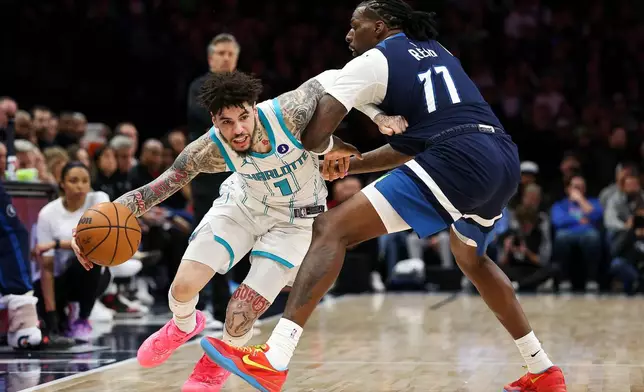 FILE - Charlotte Hornets guard LaMelo Ball (1) works around Minnesota Timberwolves center Naz Reid (11) during the second half of an NBA basketball game, April 5, 2026, in Minneapolis. (AP Photo/Matt Krohn, file)