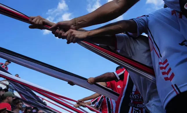Chacarita Juniors fans hoist a flag from the stands during an Argentine soccer league match against Gimnasia y Tiro in Buenos Aires, Argentina, Sunday, April 12, 2026. (AP Photo/Rodrigo Abd)