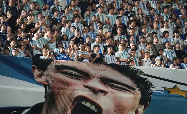 Fans wait for the start of a friendly soccer match between Argentina and Zambia next to a banner of Argentine soccer legend Diego Maradona in Buenos Aires, Argentina, Tuesday, March 31, 2026. (AP Photo/Rodrigo Abd)