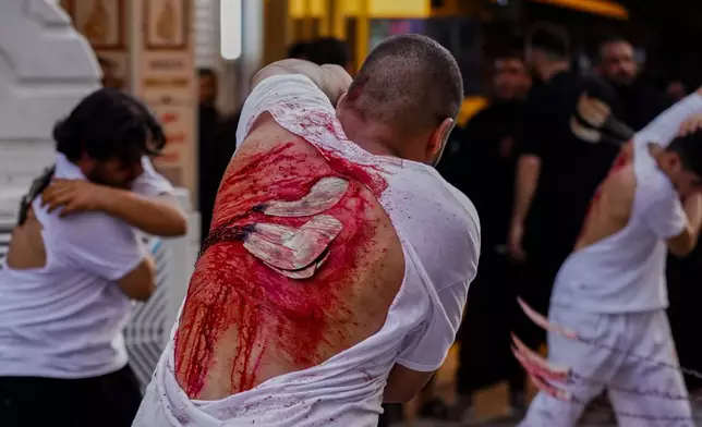 EDS NOTE: GRAPHIC CONTENT - Shiite faithful pilgrims flagellate themselves as a sign of grief for Imam Hussein during a Muharram procession, in Najaf, Iraq, Tuesday, June 23, 2026. (AP Photo/Anmar Khalil)
