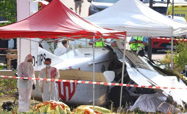 Forensic technicians examine a skydiving plane that crashed in Tomblaine northeastern France, killing all 11 people on board, Sunday, June 28, 2026. (AP Photo/Antonin Utz)