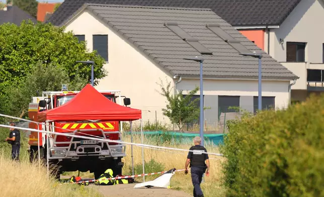 Police officer stands near the site where a skydiving plane crashed in Tomblaine northeastern France, killing all 11 people on board, Sunday, June 28, 2026. (AP Photo/Antonin Utz)