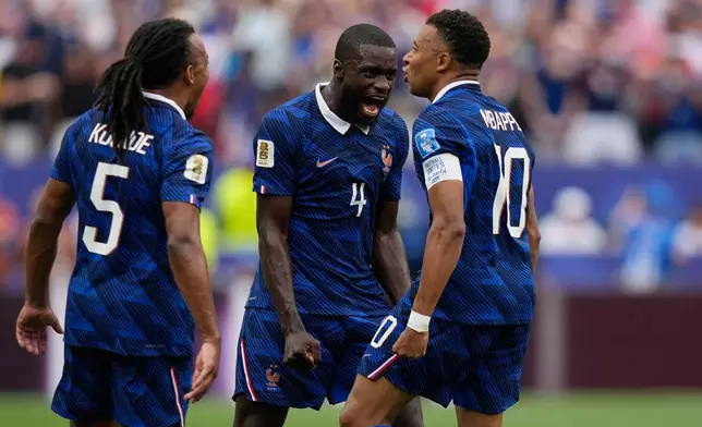 France's Dayot Upamecano, center, congrats Kylian Mbappe, right, after he scored during the World Cup Group I soccer match between France and Iraq in Philadelphia, Monday, June 22, 2026. (AP Photo/Matt Slocum)